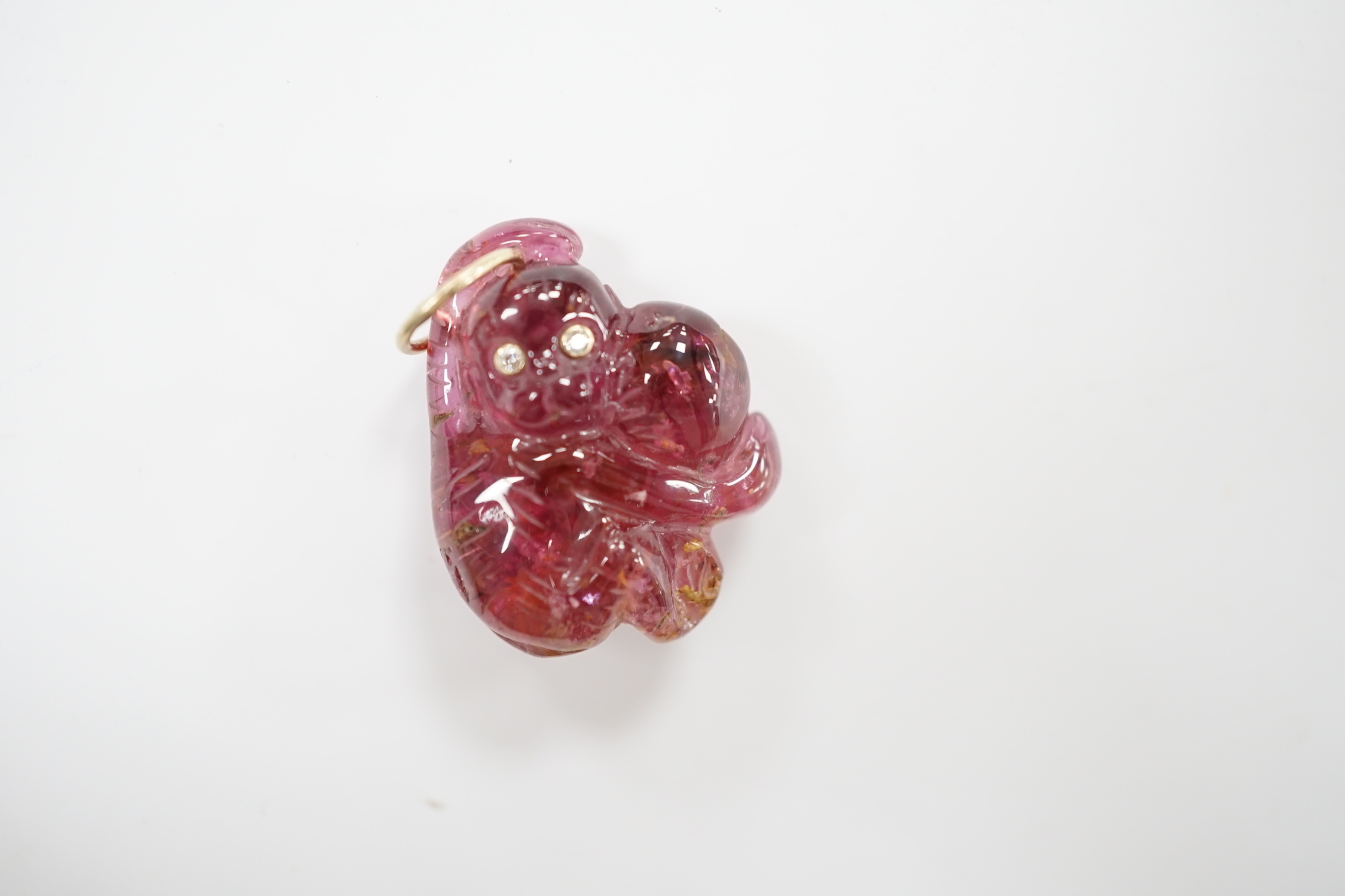 A novelty pink tourmaline and two stone diamond set pendant, modelled as a monkey, 25mm.